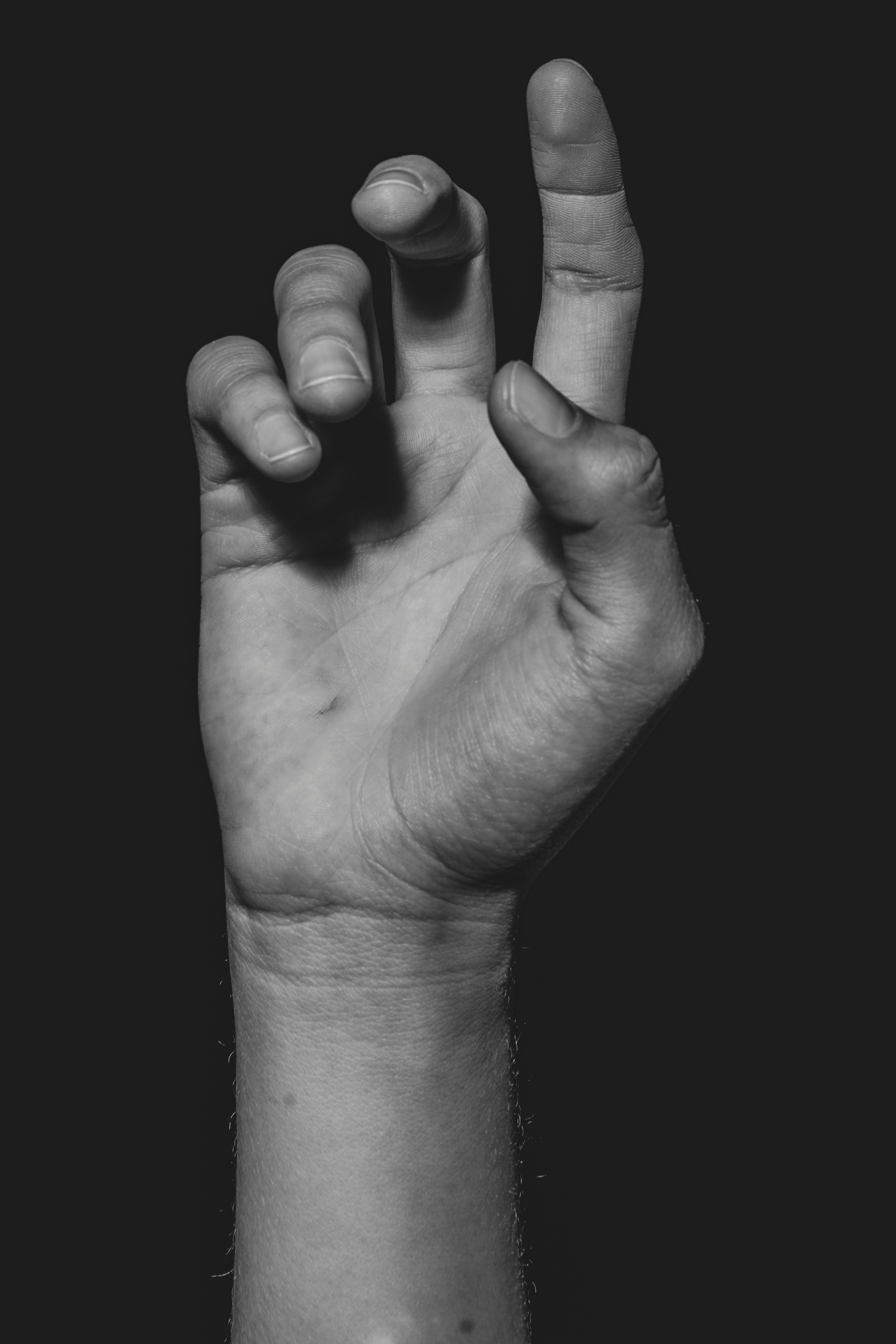 Photo of a hand raised in a black background